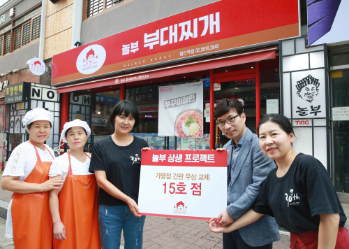박은자 놀부부대찌개 철산역점 점주(왼쪽에서 세번째)와 본사 상생협력팀 박용형 팀장(오른쪽에서 두번째)이 철산역점 간판을 교체한 후 매장 앞에서 기념 촬영을 하고 있다. [사진제공 ...
