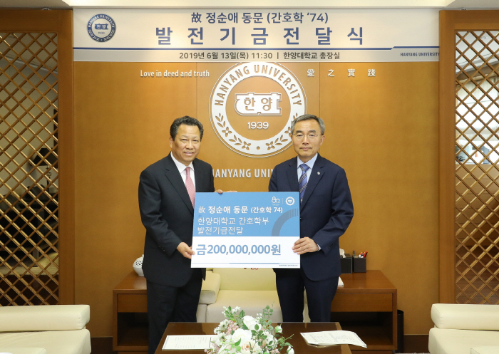 故 정순애 한양대병원 간호사 유족(왼쪽)이 13일 한양대에서 김우승 총장에게 기부금을 전달하고 있다.