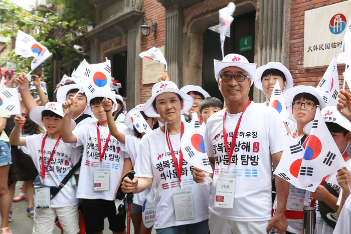 14일 중국 상하이 대한민국 임시정부 옛 청사 앞에서 김명환 덕신하우징 회장(가운데)과 독립유공자 후손 초등학생 등이 3.1운동 및 임시정부수립 100주년을 맞아 태극기를 흔들며 ...