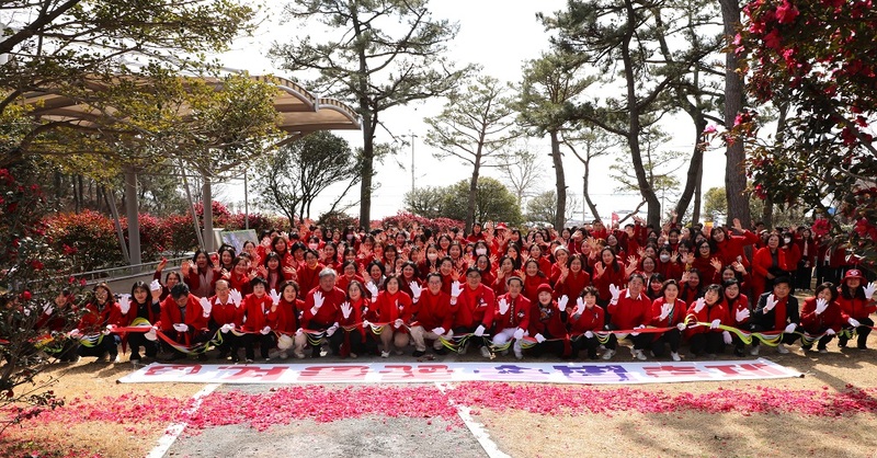 2025 섬 겨울꽃 송별축제에서 참가자들이 동백 꽃잎을 따 퍼포먼스를 하고 있다. / 사진=신안군 제공