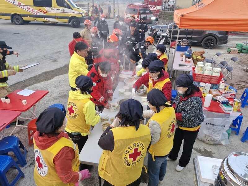◇ 23일 울산 울주군 산불 현장에서 대한적십자사 울산지사 봉사원들이 진화요원들에게 급식을 제공하고 있다.
