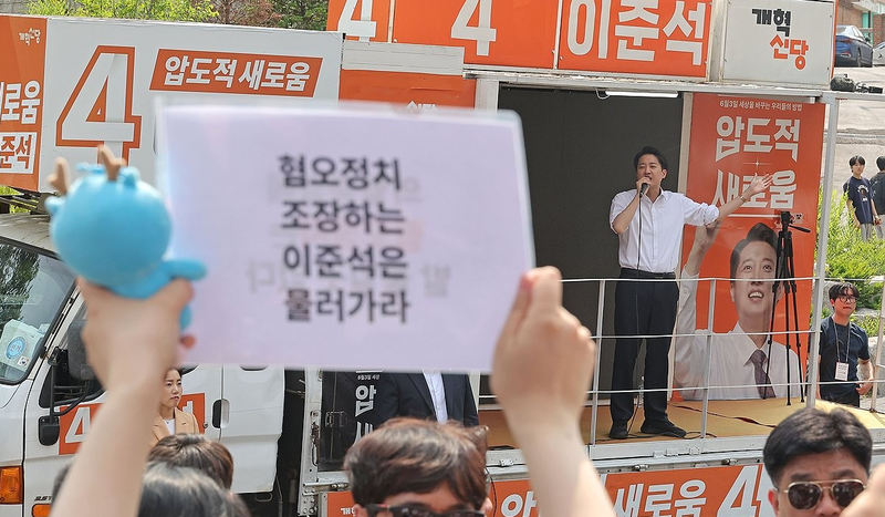 개혁신당 이준석 대선 후보가 30일 서울 동작구 중앙대학교에서 유세 중인 가운데 일부 학생들이 최근 이 후보의 TV토론 여성 신체 관련 발언을 규탄하며 팻말을 들고 있다. / 사진...