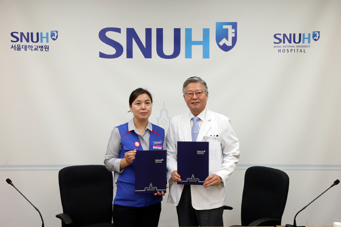 김연수 서울대병원장(오른쪽)과 김진경 지부장이 용역 비정규직의 전원 정규직화에 따른 협약을 체결한 뒤 기념사진을 촬영하고 있다.