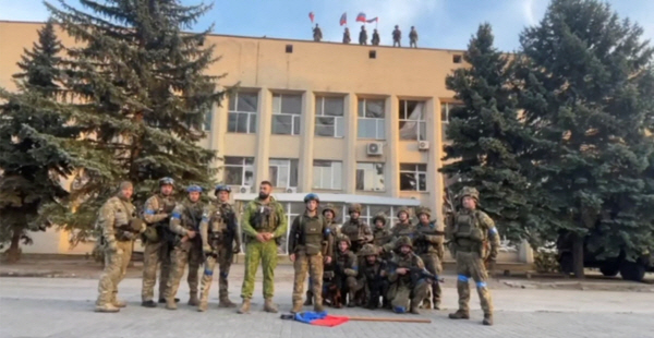 우크라이나군이 1일(현지시간) 도네츠크주 리만 시청 건물 앞에서 리만 탈환 소식을 알리고 있다. [사진 출처 = 연합뉴스]